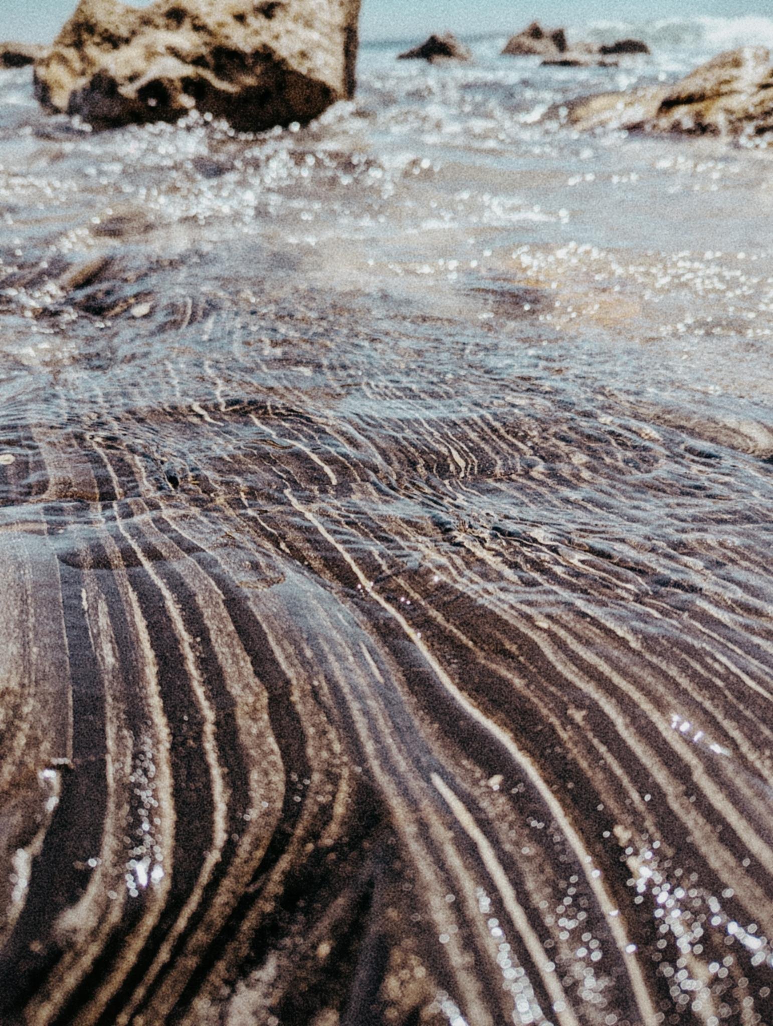 Services Clear water rippling over striped rock